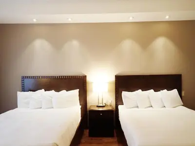two beds in a hotel room with white pillows at Days Inn & Suites by Wyndham Fort Saskatchewan in Fort Saskatchewan