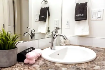 a bathroom counter with a sink and a mirror at Chic Suite - Long Stays - King Bed - Fireplace & WiFi in Edmonton