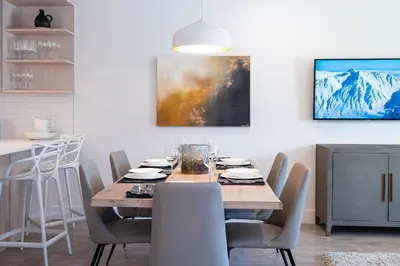 a dining room with a wooden table and chairs at The Stoke Stopover - Revelstoke Condo with Hot Tub in Revelstoke