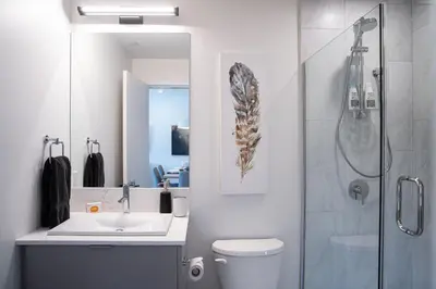 a bathroom with a toilet and a sink and a shower at The Stoke Stopover - Revelstoke Condo with Hot Tub in Revelstoke