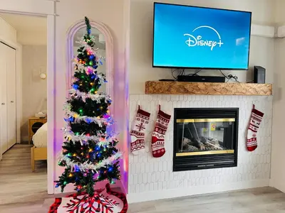 a christmas tree in a living room with a fireplace at W116 NEW! Central Canmore- Whimsical Mountain Retreat in Canmore