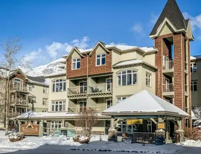 a large apartment building with snow on the ground at W116 NEW! Central Canmore- Whimsical Mountain Retreat in Canmore