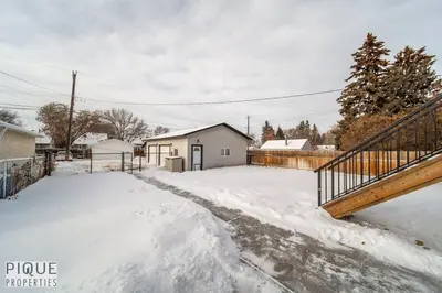 a driveway covered in snow next to a house at Boho Suite - Long Stays - King Bed - Fireplace & WiFi in Edmonton