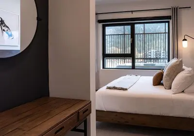 a bedroom with a bed and a window at Altitude Adjustment by Revelstoke Vacations in Revelstoke