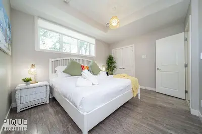 a bedroom with a large white bed and a window at BoHo Chic Suite - Long Stays - Fireplace - Garage in Edmonton