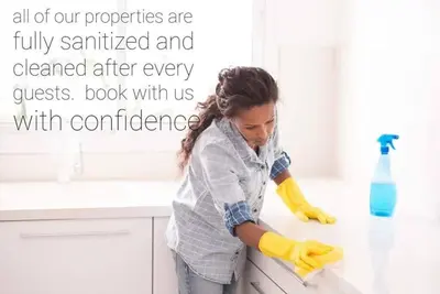 a woman cleaning a counter in a kitchen at BoHo Chic Suite - Long Stays - Fireplace - Garage in Edmonton