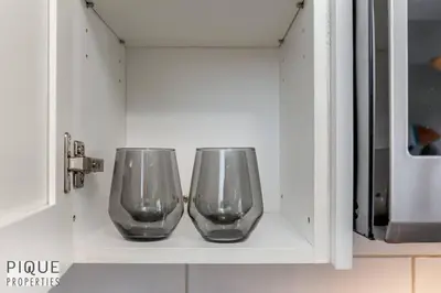two empty wine glasses sitting on a shelf in a cabinet at BoHo Chic Suite - Long Stays - Fireplace - Garage in Edmonton