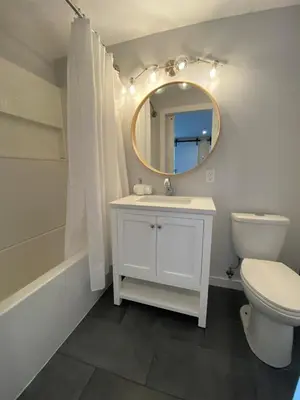 a bathroom with a sink and a toilet and a mirror at River's Edge Retreat in Clearwater