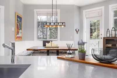 a kitchen with white walls and a table and a sink at 2BR in Granite Court, Village Location, Gas Fireplace, Mudroom, Secure Parking in Whistler