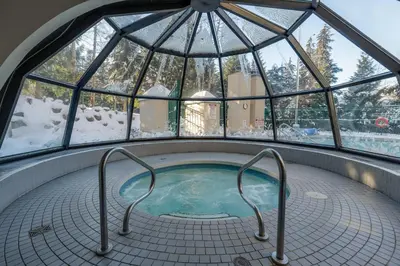a hot tub in a room with a glass dome at 1BR in Marquise, Near Ski Hill, Fireplace, Heated Pool, Hot Tub, Sauna, Gym, Free Shuttle in Whistler