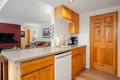 a kitchen with wooden cabinets and a counter top at 2BR in Valhalla, Whistler Village, Complex Hot Tub, Gas Fireplace, Parking, Gondola Shuttle in Whistler
