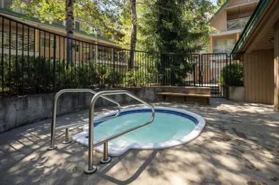 a hot tub with a hand rail in a yard at 2BR in Valhalla, Whistler Village, Complex Hot Tub, Gas Fireplace, Parking, Gondola Shuttle in Whistler