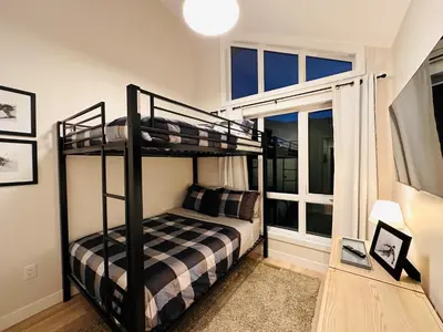 a bedroom with two bunk beds and a window at Ski In Ski Out Private Hot Tub in Panorama