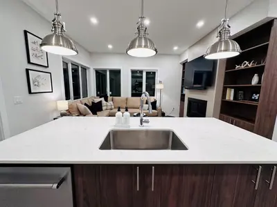 a kitchen with a sink and a living room at Ski In Ski Out Private Hot Tub in Panorama