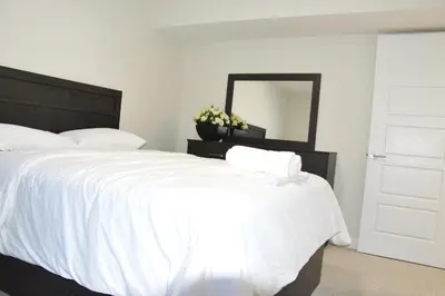 a bedroom with two white beds and a mirror at Secondary Suite, Separate Entrance NW Calgary in Calgary