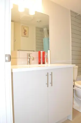 a white bathroom with a sink and a mirror at Secondary Suite, Separate Entrance NW Calgary in Calgary
