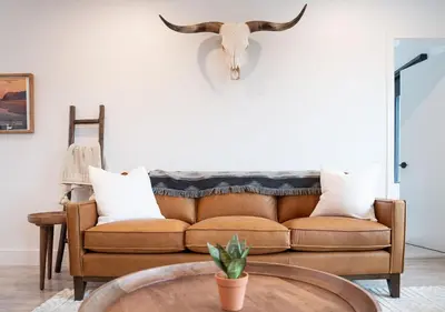a living room with a couch and a bull skull on the wall at Hemlock Hangout by Revelstoke Vacations in Revelstoke