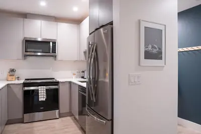 a kitchen with a stainless steel refrigerator and appliances at Hemlock Hangout by Revelstoke Vacations in Revelstoke