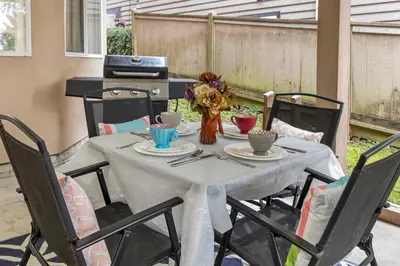 a table with a white table cloth and chairs at Pristine 3 Beds 2 Washroom Guest Suite in Surrey