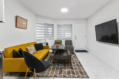 a living room with a yellow couch and a table at Pristine 3 Beds 2 Washroom Guest Suite in Surrey