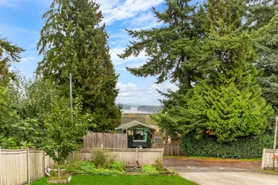 a house with two large trees in a yard at Pristine 3 Beds 2 Washroom Guest Suite in Surrey
