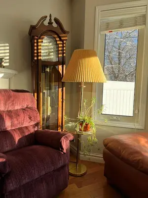 a living room with a couch and a grandfather clock at Lovely comfy home private bath in central Calgary in Calgary