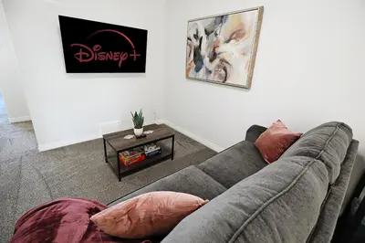 a living room with a couch and a table at Three King Beds,Central A/C,Fireplace,Park,Disney+ in Edmonton