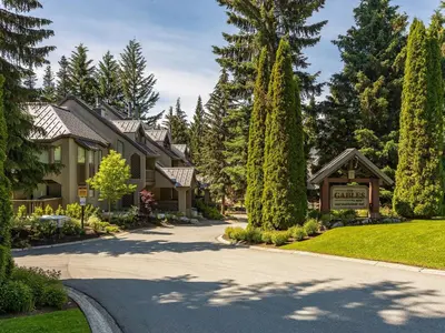 a house with trees and a driveway at 2BR in The Gables, Prime Location, Steam Shower, Heated Flooring, Wood Burning Fireplace in Whistler