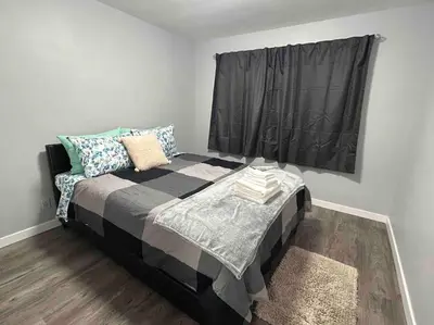 a bedroom with a large bed with a window at Cute Highland Park(Upper-A-Unit) in Calgary