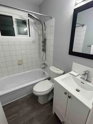 a white bathroom with a toilet and a sink at Cute Highland Park(Upper-A-Unit) in Calgary