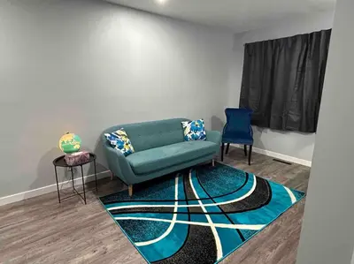a living room with a green couch and two chairs at Cute Highland Park(Upper-A-Unit) in Calgary