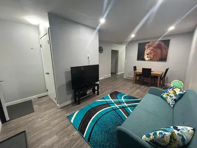 a living room with a blue couch and a television at Cute Highland Park(Upper-A-Unit) in Calgary