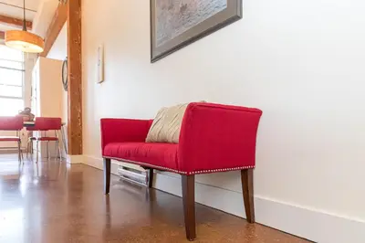 a red chair sitting in a room with a table at Be Vogue In Old Town Victoria in Victoria