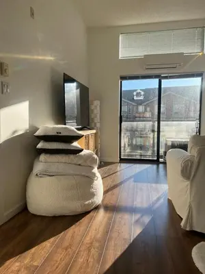 a living room with a couch and a stack of pillows at Laid Back In Langford in Langford