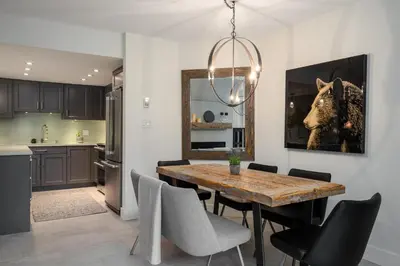 a kitchen and dining room with a wooden table and chairs at 3BR and Den in Gleneagle, Wood Burning Fireplace, Heated Flooring, Secure Parking in Whistler