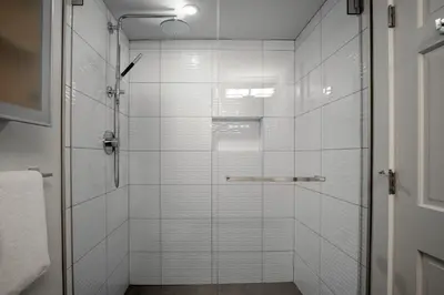 a shower with a glass door in a bathroom at 3BR and Den in Gleneagle, Wood Burning Fireplace, Heated Flooring, Secure Parking in Whistler