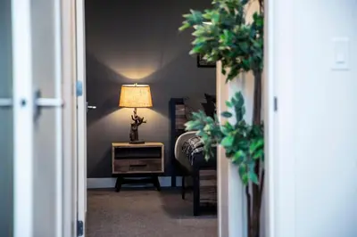 a room with a lamp and a table with a chair at Absolutely Revy - Ground Level Condo in Revelstoke in Revelstoke
