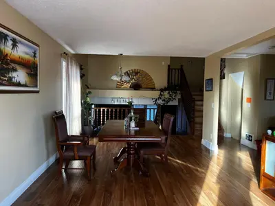 a dining room with a wooden table and chairs at Beddington masteroom close airport! in Calgary
