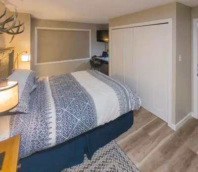 a bedroom with a bed and a sliding door at 2 Bedroom and Wall Bed Mountain Getaway Ski In Ski Out Condo with Hot Pools Sleeps 8 in Panorama