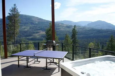 a hot tub and a table on a balcony with mountains at Five Star-Amazing views and Hot Tub in Crescent Valley