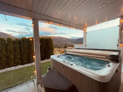 a hot tub on a patio with a view at Relaxing 3 bedroom suite, near Silver Star Resort in Vernon