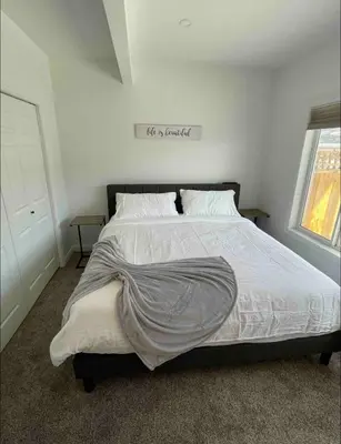 a bed with a blanket on it in a bedroom at Relaxing 3 bedroom suite, near Silver Star Resort in Vernon