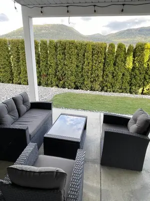 a patio with two couches and a table and chairs at Relaxing 3 bedroom suite, near Silver Star Resort in Vernon