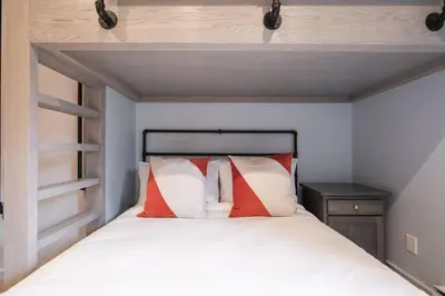 a bed with red and white pillows in a room at Treeline by Outpost Whistler in Whistler
