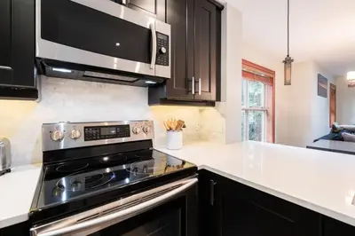 a kitchen with a stove and a microwave at Treeline by Outpost Whistler in Whistler
