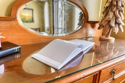 a mirror on a dresser with a book on it at First Place in Strathmore