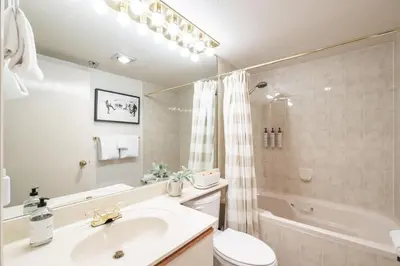 a bathroom with a sink and a toilet and a tub at Foxglove by Outpost Whistler in Whistler