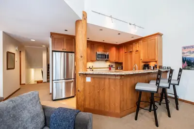 a kitchen with wooden cabinets and a counter top at Blackcomb Greens by Outpost Whistler in Whistler