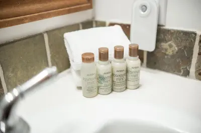 three bottles of lotion sitting on a bathroom sink at Spruce Grove Chalet by Outpost Whistler in Whistler