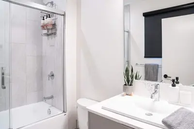 a white bathroom with a sink and a shower at Revytalise - Cozy 3 Bedroom Condo in Revelstoke